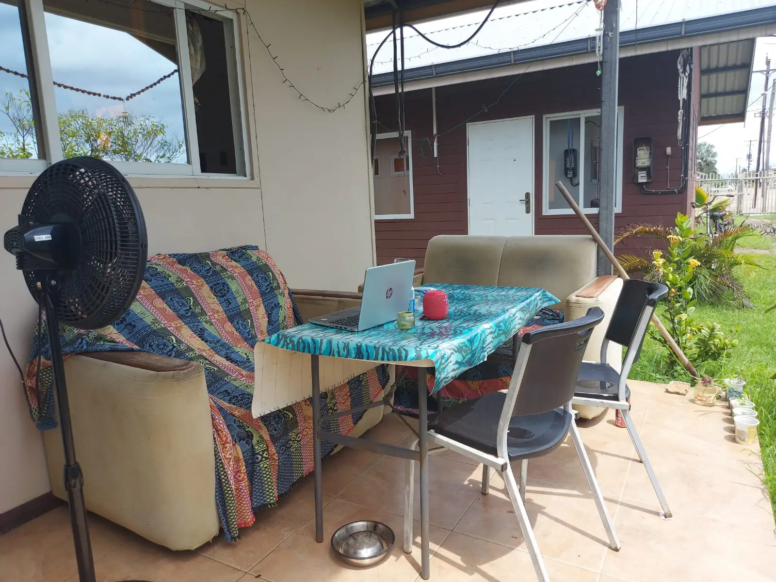 Overdekte veranda met een ventilator, een bank en een tafeltje