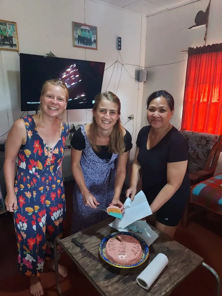 Drie vrouwen bij een tafel met een schaal eten in een woonkamer