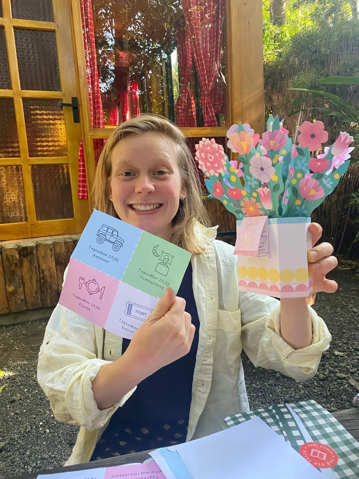 Lachende vrouw met een pop-upkaart met bloemen en nog een kaart