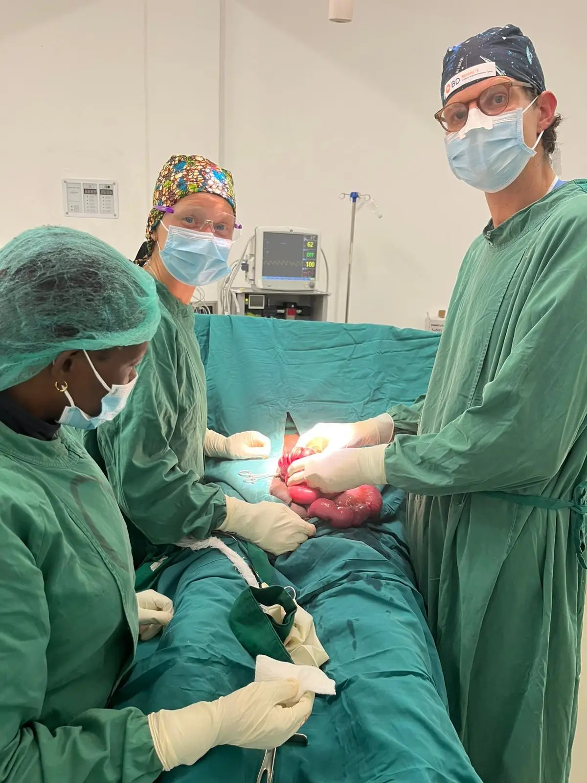 Operatieteam in groene kleding en met mondkapjes tijdens een operatie