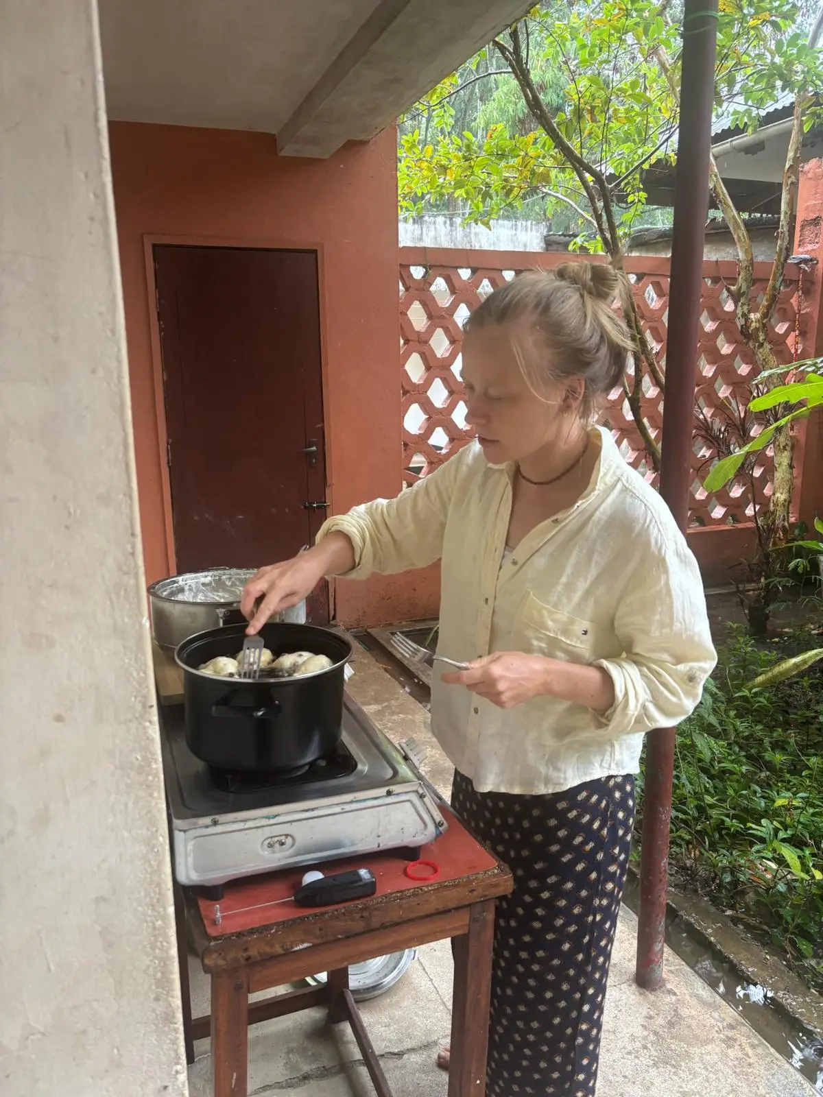 Vrouw kookt op een veranda