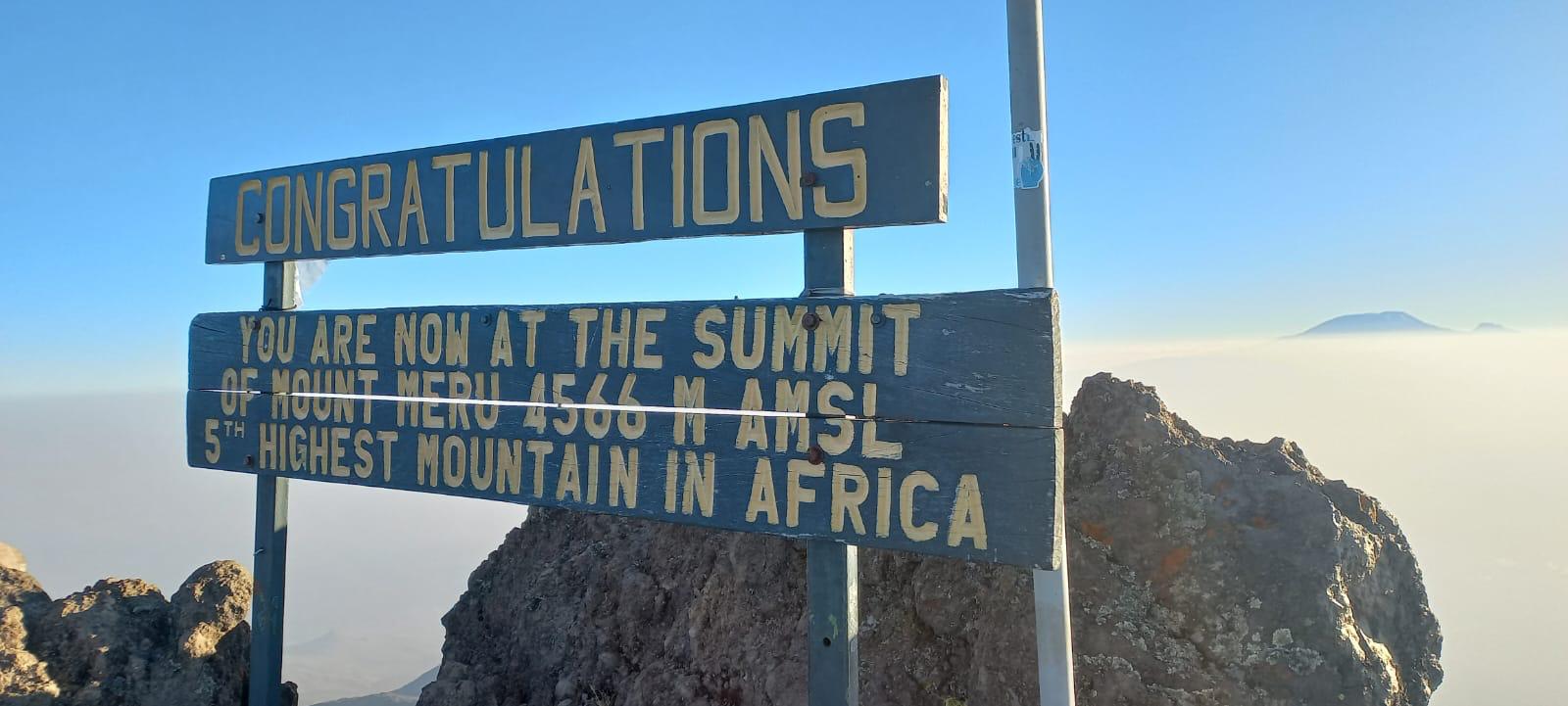 Topbord van Mount Meru met het woord ‘Congratulations’ boven de wolken